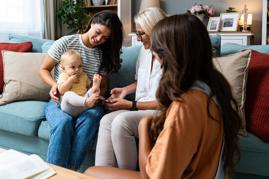 Happy family. Grandmother, mother, aunt and little baby having fun at home. Relatives visiting new born child.
