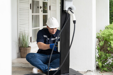 Qualified technician install home EV charging station, providing maintenance service for electric...