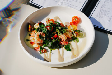 A beautiful calamari plate in a beach restaurant on a restaurant table with a menu next to it