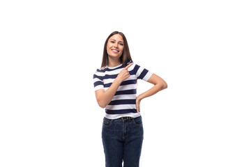 attractive young caucasian brunette woman in a striped t-shirt points with her hands to the advertising space on a white background with copy space