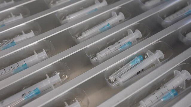 Medical syringe production plant. New syringes with needle on conveyor line. Equipment for the production of disposable syringes.
