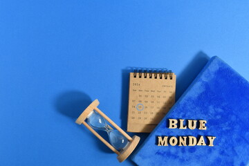 Blue diary with hourglass and calendar on blue background. Top view