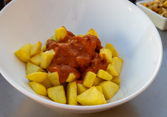 Patatas bravas on a white bowl, spanish tapas