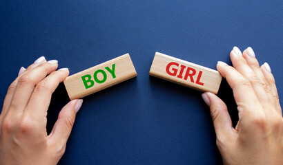 Boy or Girl symbol. Concept word Boy or Girl on wooden blocks. Man hand. Beautiful deep blue...