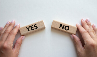 Yes or No symbol. Concept word Yes or No on wooden blocks. Businessman hand. Beautiful white background. Business and Yes or No concept. Copy space - obrazy, fototapety, plakaty