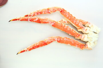 frosted Alaska king crab legs close up photo on white table background