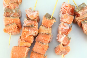 frosted salmon pieces on wooden skewers stick close up photo 