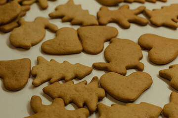 Ready gingerbread cookies on a white table. Christmas brown cookies. Festive background. Sweet homemade cakes for children.