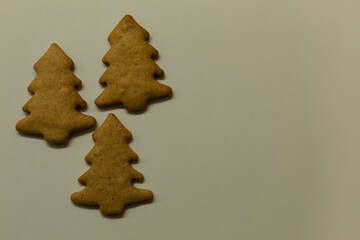 Figured cookies in the shape of Christmas trees. Christmas gingerbread cookies on a white background. Free space for writing text.