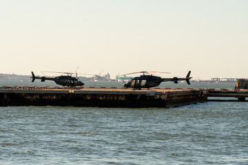 Two Helicopters at the Downtown Manhattan Heliport as seen from a ferry on the east river