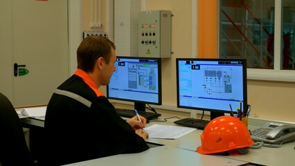 Industrial operator at plant checks machinery, ensuring industry standards. Focused on industry...