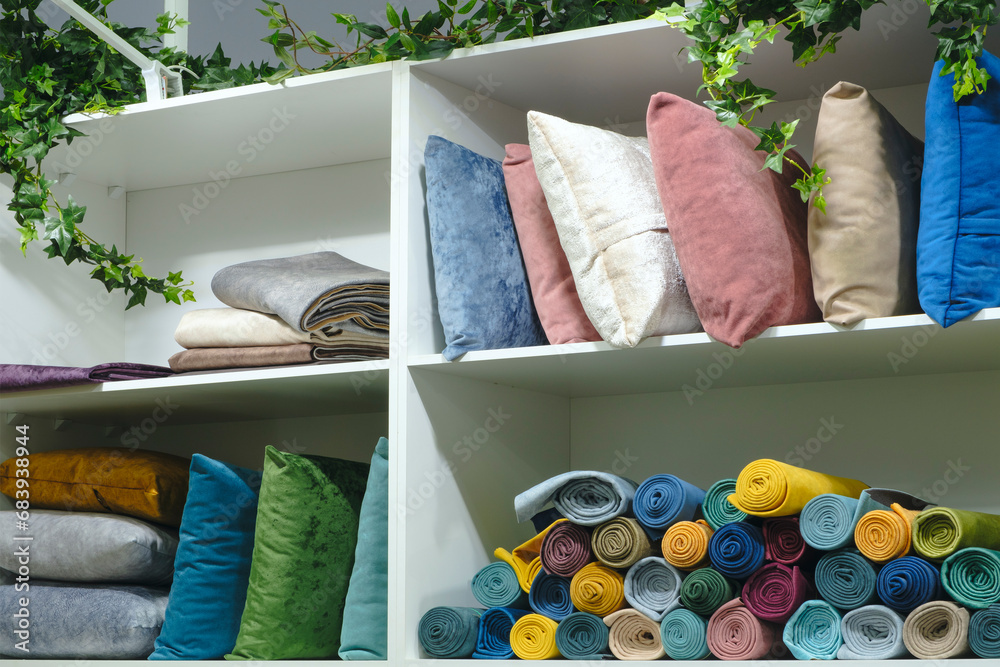 Poster shelves in a store with colorful pillows and towels