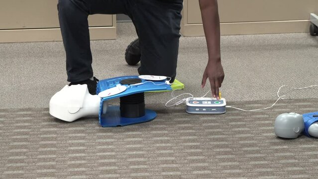 Emergency and Standard First aid, AED machine and CPR training class by a security guard in an office building