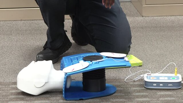 Emergency and Standard First aid, AED machine and CPR training class by a security guard in an office building