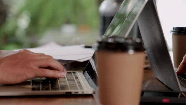 Worker relaxing free time after lunch in coffee shop, freelancer or group of employees business talking partnership running small restaurant shop owner, unrecognizable hands typing keyboard on laptop