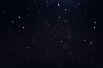 falling snow on a dark background, winter snowy background for design and overlay