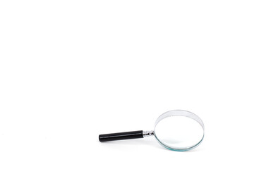 A photo featuring a magnifying glass with a black handle and a silver rim around the magnifying...