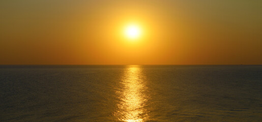 Naklejka na ściany i meble Sunset with sun path on surface of sea.