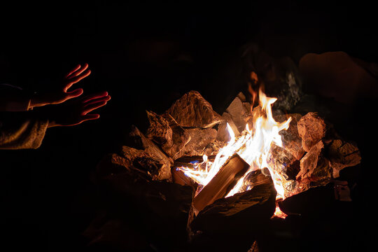 Woman by the fire. Silhouette of a person in the light of a flame. Open flame. Warming up by the fire. A witch's spell. Female magic. Konotop Witch.