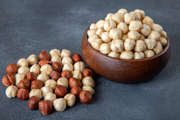Top view of a bowl full of peeled hazelnuts on black background,top view