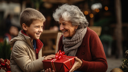 Fototapeta na wymiar grandson gives a gift to his grandmother, a little boy congratulates an elderly woman on Christmas, New Year, Elderly Day, child, kid, son, happy face, emotions, joy, holiday, present, box, lady