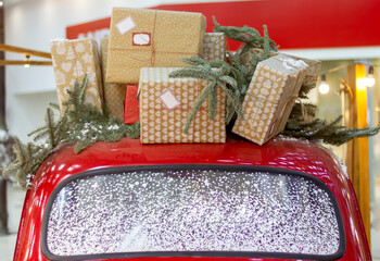 there are a lot of Christmas and New Year gifts on the roof of a red car, close-up decor in retro style - Powered by Adobe