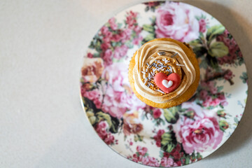 Decorated cupcake on a floral plate, love hearts