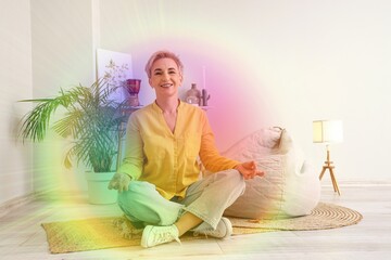 Mature woman with colorful aura meditating at home. Zen concept