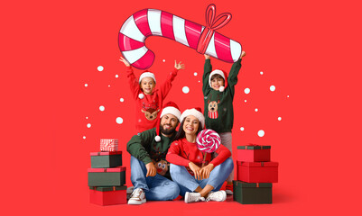 Happy family in Santa hats, with Christmas gifts and candies on red background - obrazy, fototapety, plakaty