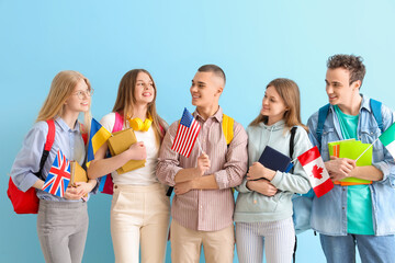Group of students with books and flags of different countries on blue background