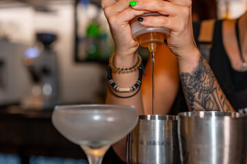Hands of bartender preparing a cocktail with shaker