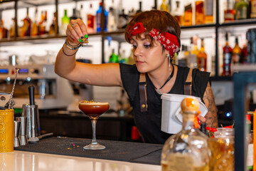 Bartender decorating the top of a cocktail