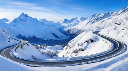 A panoramic view of a serpentine road snaking through a pristine alpine landscape under a brilliant blue sky, flanked by snow-dusted mountains and evergreens.