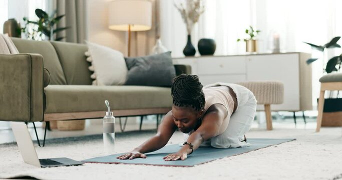 Yoga, laptop or black woman stretching in home or house studio for wellness, peace or balance. Pilates, online tutorial or African person in cat pose for energy training, spine or holistic exercise