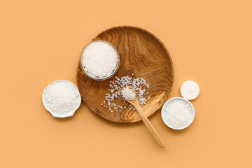 Composition with different bowls of sea salt on color background