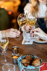 A group of girls in a restaurant clink glasses with champagne. Celebrate a holiday or a bachelorette party before the wedding