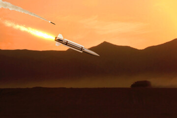 Military missile flies against a background of mountains and desert, smoke and fire. Concept:...