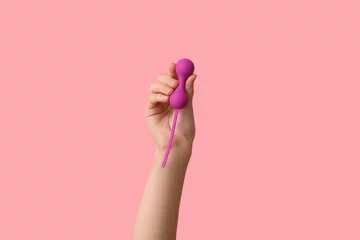 Foto auf Alu-Dibond Female hand with vaginal balls on pink background, closeup © Pixel-Shot