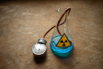 A bottle of blue radioactive liquid is on the table. Experiments with contaminated water in a glass...