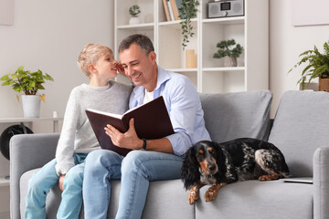 Mature doctor with his little son and photo album at home