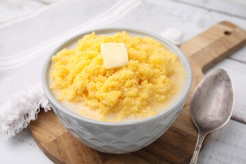 Tasty cornmeal with butter in bowl served on table, closeup