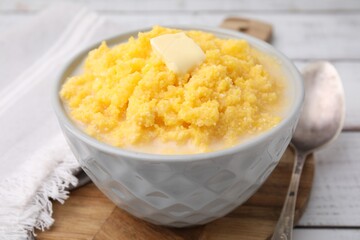 Tasty cornmeal with butter in bowl served on table, closeup