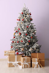 Beautiful Christmas tree and different presents near color wall
