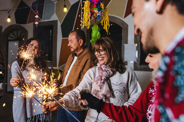 Latin family celebrating Mexican Posadas and Singing carols in Christmas eve in Mexico Latin...