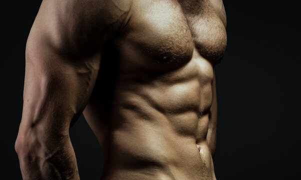 Male chest. Chest muscles. Muscled male torso with abs. Athletic Man showing muscular body and six pack. Naked gay posing in studio. Man showing sexy body. Athletic muscles.