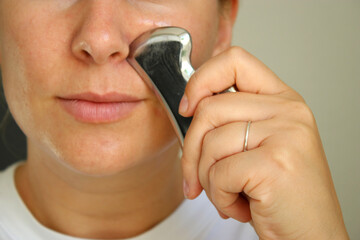 Young caucasian woman using a metal gun she tool for lifting the face