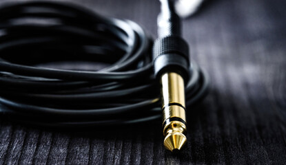 audio cable with Jack and mini jack connector, on a dark table, close up view