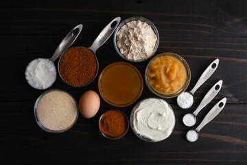 Baked Apple Cider Donuts Ingredients on a Wooden Table: Apple sauce, Greek yogurt, and other ingredients to make a healthier doughnut recipe