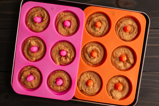 Baked Apple Cider Donut Batter in Silicone Donut Molds: Pastry batter that has been piped into silicone doughnut molds ona sheet pan