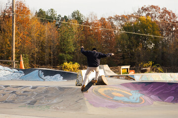 Skater Performing Trick at Urban Skatepark with Artistic Graffiti Background